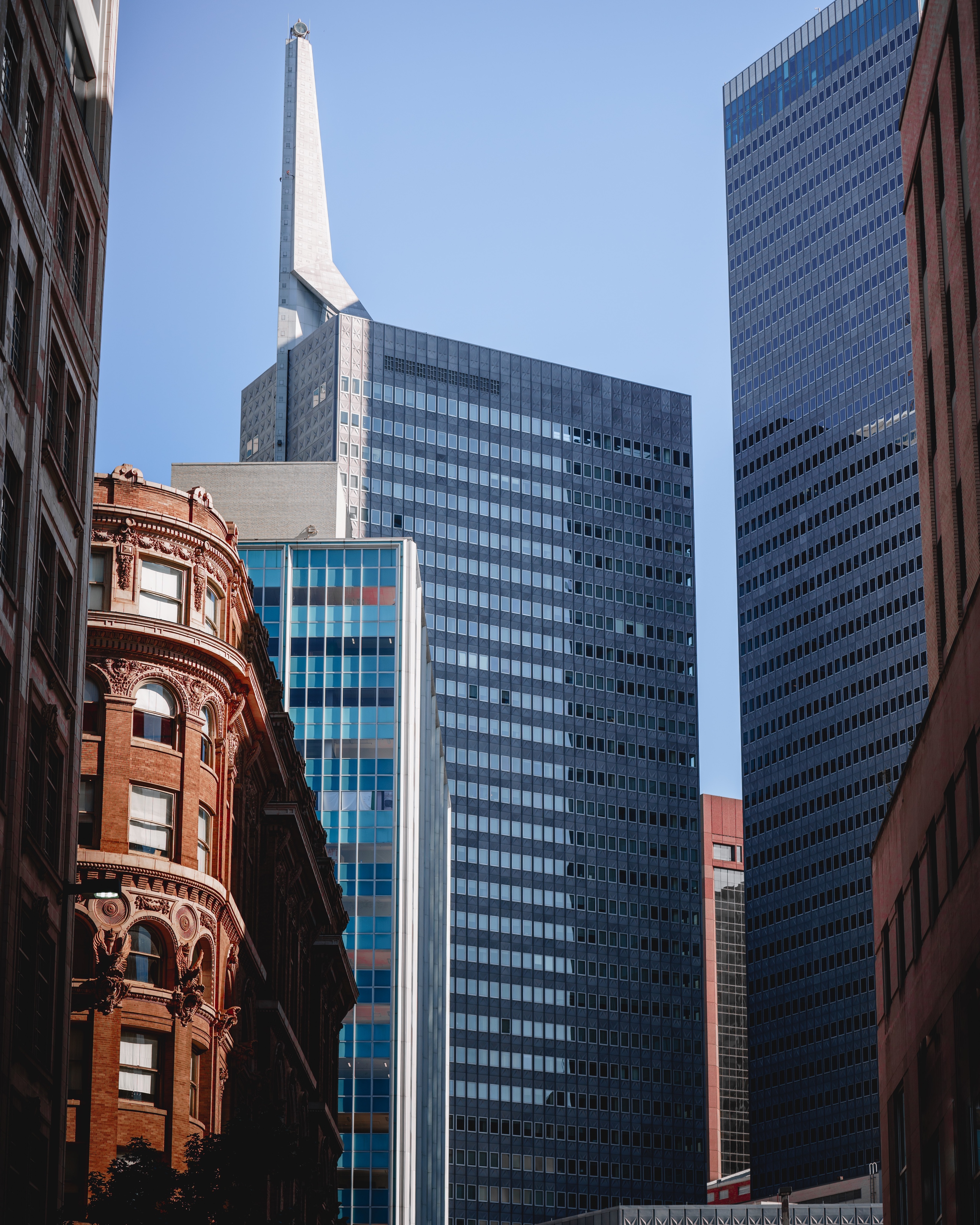 Image of a tall modern building alongside an old stylish red-brick building